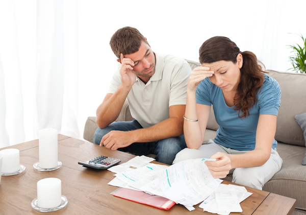 Worried couple doing their accounts in the living room at home